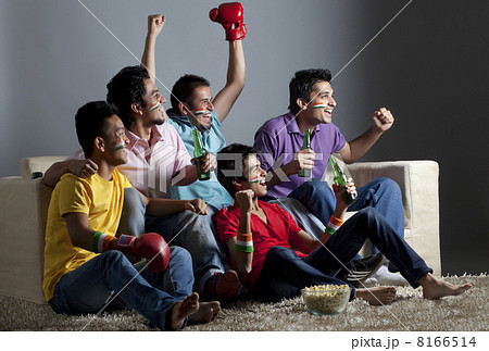 Enthusiastic male friends watching boxing match together at home Enthusiastic male friends watching boxing match together at home 8166514