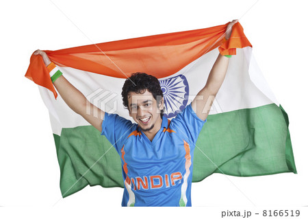 Portrait of young man in Indian cricket team jersey holding national flag over white background 8166519