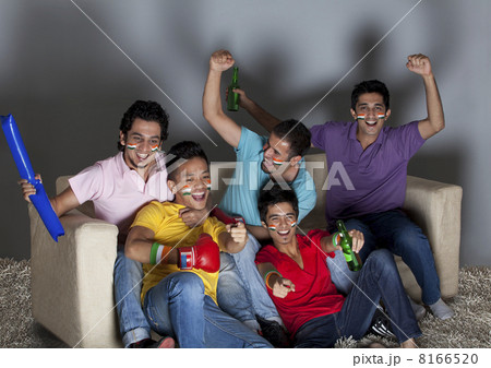 Happy young male friends enjoying a boxing match together at home 8166520