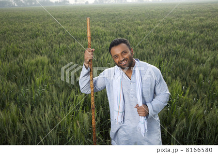 Portrait of an Indian man holding a stick 8166580