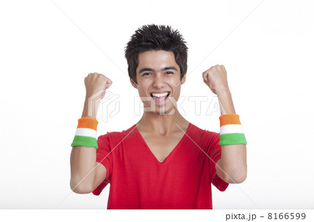 Portrait of happy teenage boy in red t-shirt cheering with clenched fists over white background 8166599