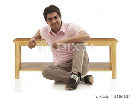 Portrait of a young man sitting on floor over white background 8166684