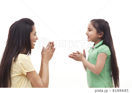 Side view of mother and daughter clapping over white background 8166685