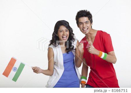 Portrait of happy young girl holding Indian flag while standing with friend over white background Portrait of happy young girl holding Indian flag while standing with friend over white background 8166751