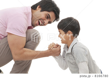 Cheerful father and son arm wrestling over white background 8166780