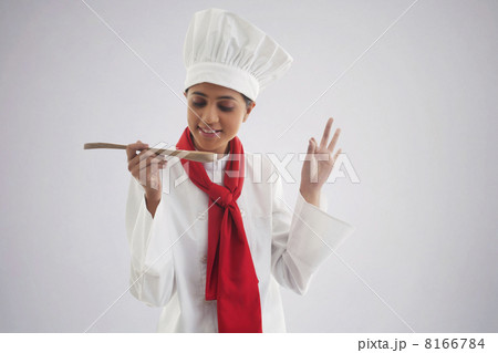 Female chef tasting food isolated over gray background Female chef tasting food isolated over gray background 8166784