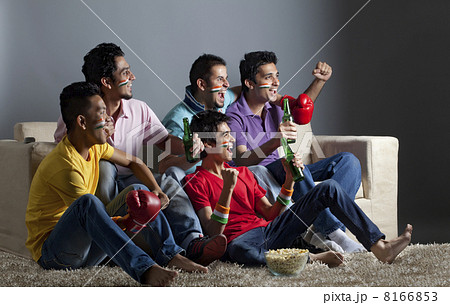 Excited male friends watching boxing match together at home 8166853