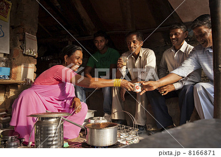 Mature woman passing cup of tea to male customer at stall 8166871