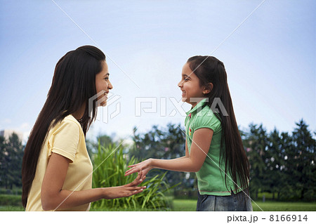 Profile view of happy mother and daughter playing over white background 8166914