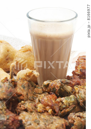 Glass of chai with pakoras , bhajiyas and fried potato balls isolated over white background 8166977