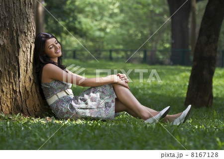 Young woman leaning against a tree 8167128