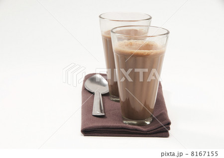 Glasses of chai and steel spoon kept on table napkin isolated over white background 8167155