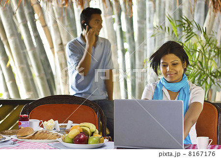 Woman sitting on breakfast table with laptop 8167176