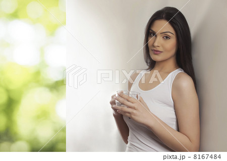 Portrait of an attractive young woman holding tea cup Portrait of an attractive young woman holding tea cup 8167484