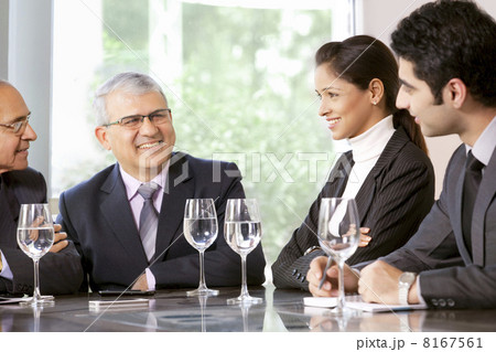 Young business professionals sitting with senior male executives in office 8167561