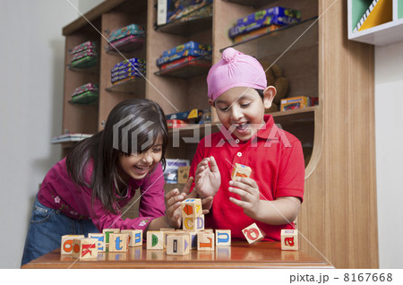Happy brother and sister playing with wooden toy blocks 8167668