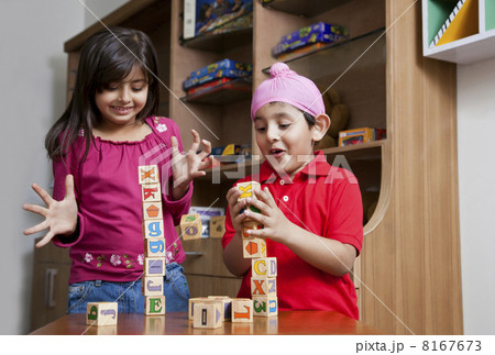 Siblings playing with wooden toy blocks 8167673
