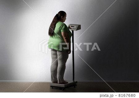 Obese woman checking her weight 8167680