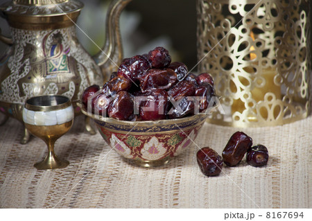 Fresh dates in ornamental bowl with kettle and cup on a tablecloth 8167694