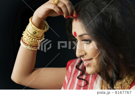 Bengali woman putting sindoor on her forehead 8167767