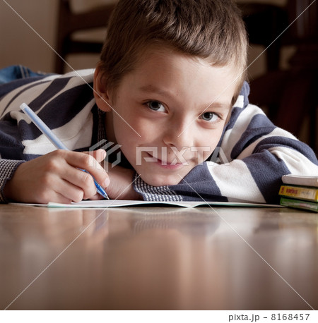 Boy does lessons lying on the floor Boy does lessons lying on the floor 8168457