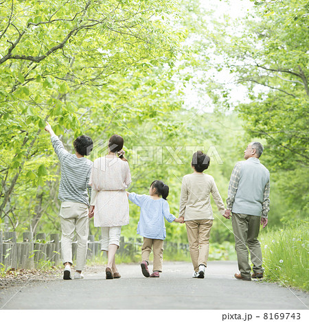 新緑の中で手をつなぐ3世代家族の後姿 8169743