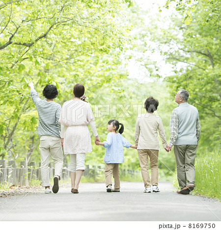 新緑の中で手をつなぐ3世代家族の後姿 8169750