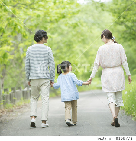 新緑の中で手をつなぐ家族の後姿 8169772