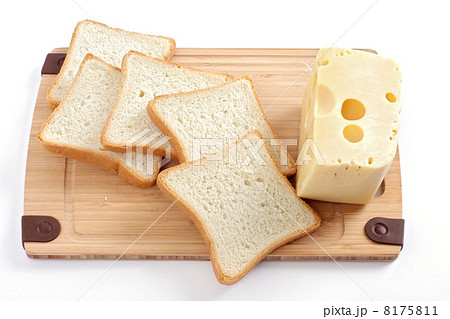 Fresh sliced loaf of bread on wooden chopping board with cheese Fresh sliced loaf of bread on wooden chopping board with cheese 8175811