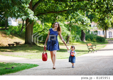 Beautiful mother and little daughter walking in summer park 8185951