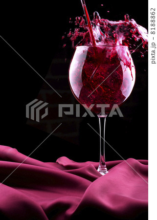 Glass of wine on red silk 8188862