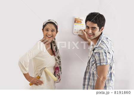 Portrait of young couple selecting color for their wall Portrait of young couple selecting color for their wall 8191860