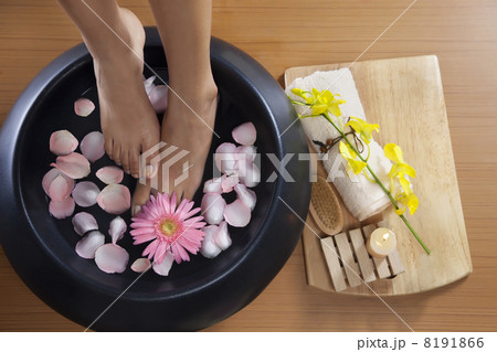 Woman soaking feet in bowl of water at spa Woman soaking feet in bowl of water at spa 8191866
