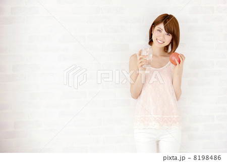 　白レンガ　壁　前で水を飲む女性 8198486