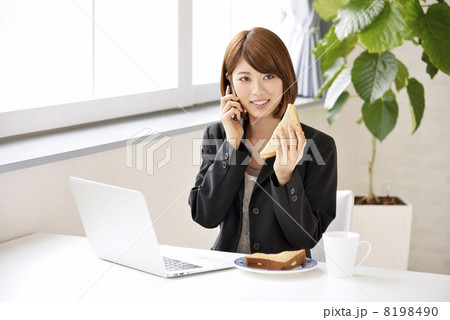 パソコンを見ながら電話をする女性 パソコンを見ながら電話をする女性 8198490