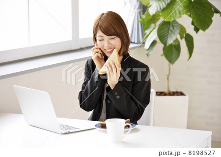 パソコンを見ながら電話をする女性 パソコンを見ながら電話をする女性 8198527