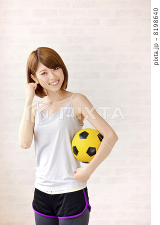 サッカーボールを持つスポーツウェアの女性の写真素材