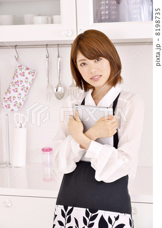 キッチンに立ちタブレットをする女性 8198735