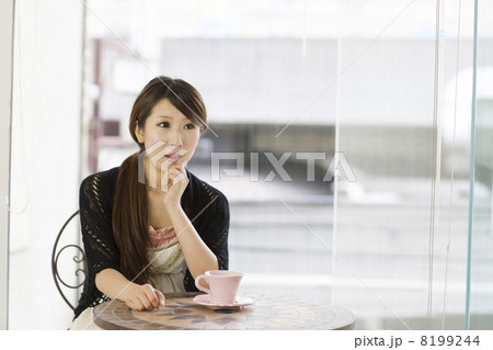 窓辺で頬杖をついて会話する若い女性 8199244