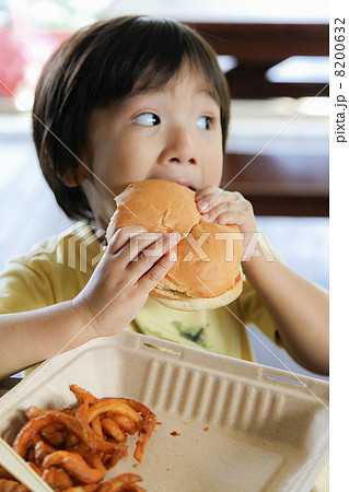 ハンバーガーを食べる子供の写真素材