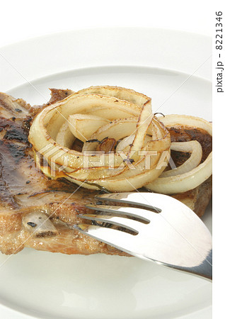 grilled pork rips with onion rings on a plate 8221346