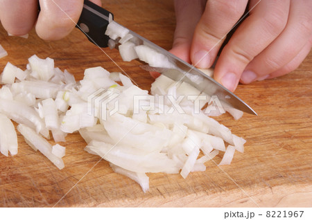 cut one organic onion, two hands and a knife 8221967