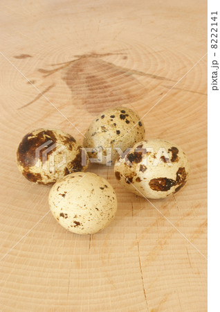 four organic quail eggs on a timber board four organic quail eggs on a timber board 8222141