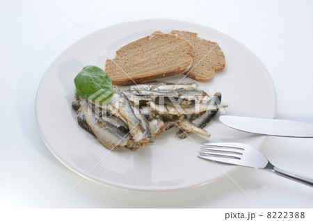 some sprats and bread on a white plate some sprats and bread on a white plate 8222388