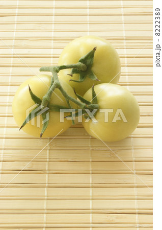 some fresh green organic tomatoes and a bamboo mat 8222389