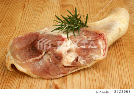 raw knuckle of pork with rosemary on a wooden board 8223663