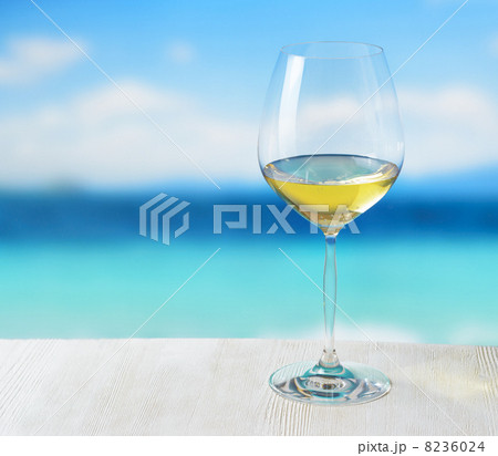 Glass of wine on beach background Glass of wine on beach background 8236024