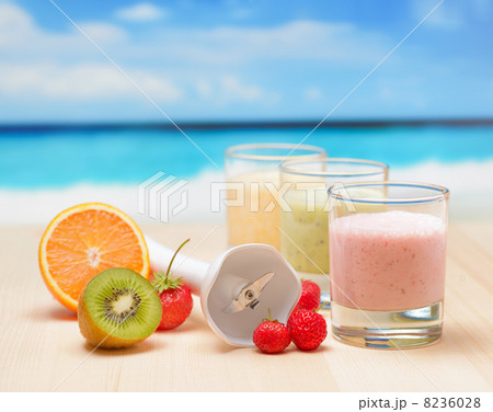 Fruit smoothie on wooden table on tropical beach 8236028