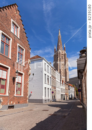 Tower and old houses in Bruges 8239180