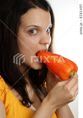 a young woman eating one red paprika 8281495